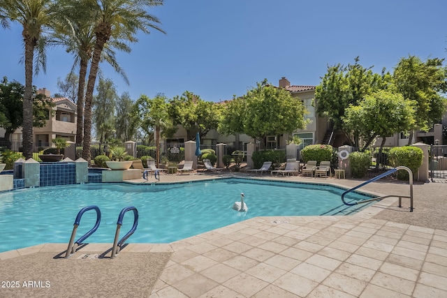 community pool featuring fence and a patio area