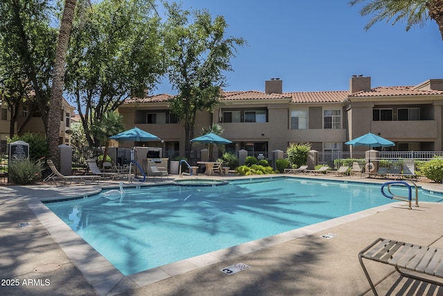 pool with a patio area and fence