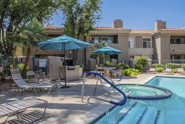 view of pool featuring fence, a pool with connected hot tub, and a patio area