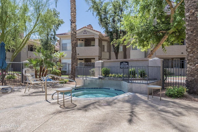 view of pool featuring fence and a hot tub