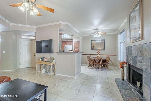 living room featuring light tile patterned floors, baseboards, ceiling fan, and ornamental molding