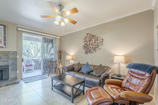 living room with a ceiling fan, ornamental molding, light tile patterned floors, and a tile fireplace