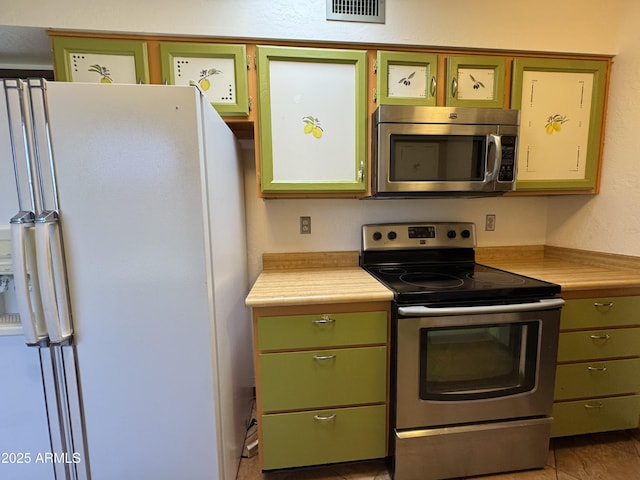 kitchen with visible vents, light countertops, green cabinetry, and appliances with stainless steel finishes
