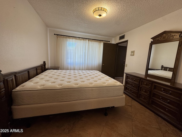 tiled bedroom featuring visible vents and a textured ceiling