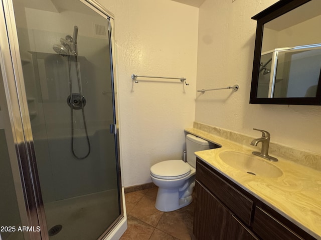 bathroom featuring vanity, tile patterned floors, a stall shower, and toilet