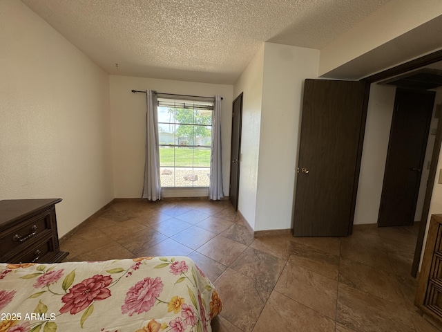 unfurnished bedroom with baseboards and a textured ceiling
