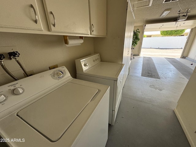 clothes washing area with cabinet space and separate washer and dryer