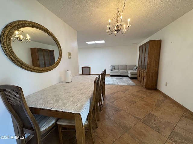 dining area featuring a textured ceiling, a notable chandelier, and stone finish floor