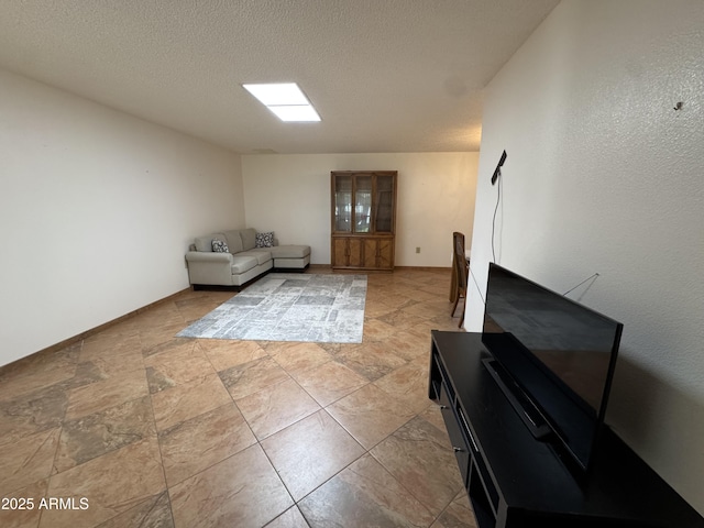 living room with baseboards and a textured ceiling