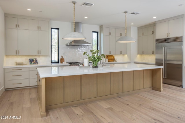 24779 N 91st St, Scottsdale, AZ 85255 - kitchen with built in fridge, wall chimney exhaust hood, light countertops, decorative backsplash, and a large island
