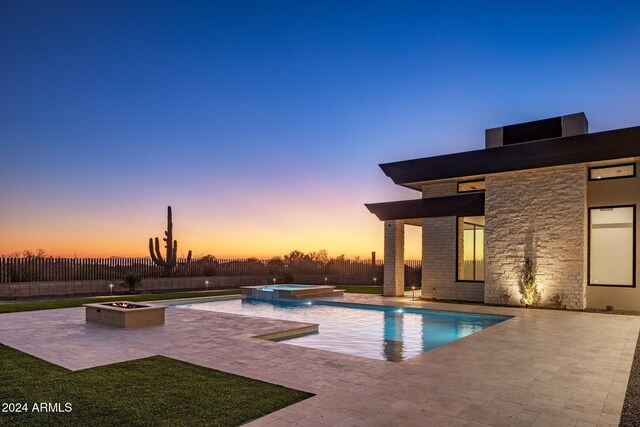 24779 N 91st St, Scottsdale, AZ 85255 - pool at dusk featuring a patio, a fire pit, and a pool with connected hot tub