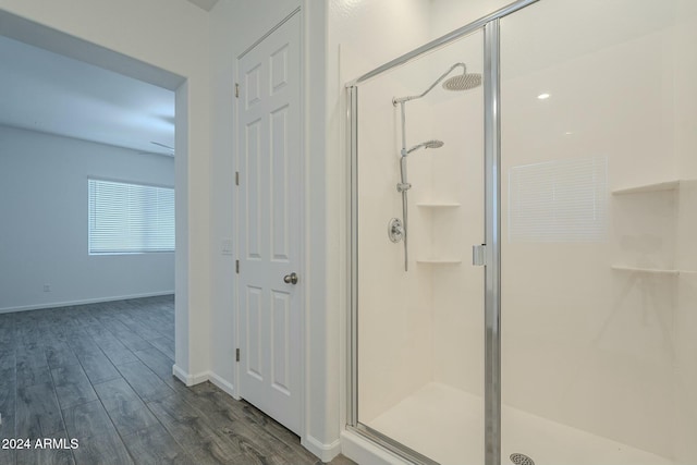 bathroom featuring wood-type flooring and a shower with door