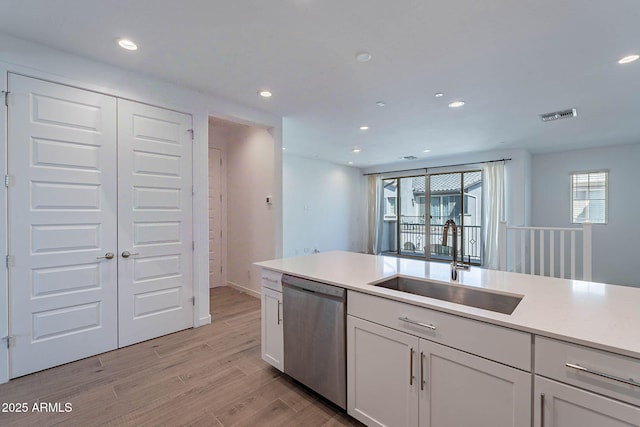 kitchen with light wood-style flooring, a sink, visible vents, stainless steel dishwasher, and a wealth of natural light