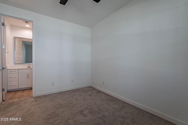 unfurnished bedroom featuring lofted ceiling, light carpet, visible vents, and baseboards