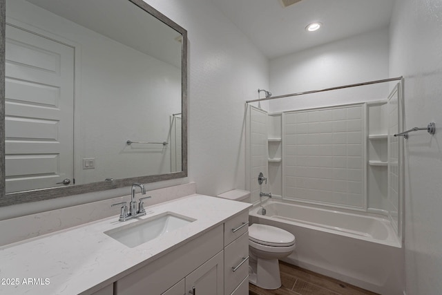 bathroom featuring toilet, wood finished floors, bathtub / shower combination, vanity, and recessed lighting