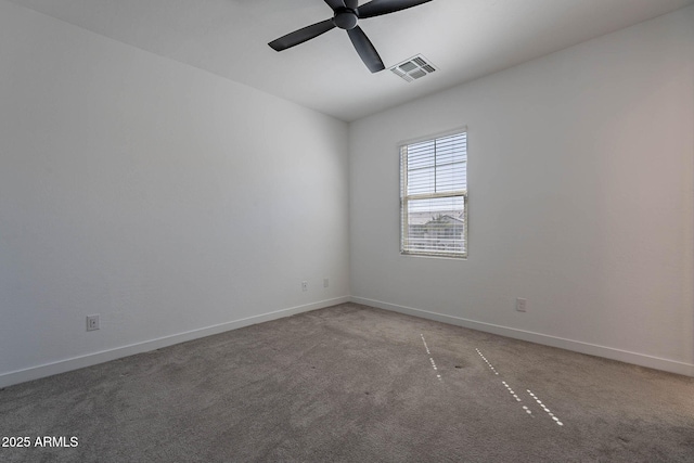 spare room with light colored carpet, visible vents, ceiling fan, and baseboards