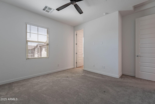 carpeted empty room featuring visible vents, ceiling fan, and baseboards