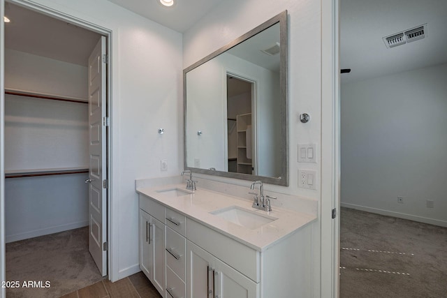 bathroom with visible vents, a sink, and baseboards