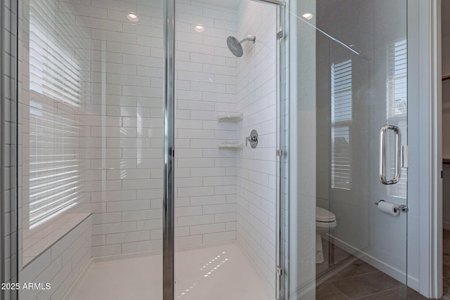 full bathroom featuring toilet and a stall shower