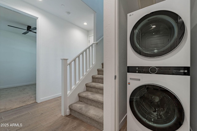 laundry area with baseboards, a ceiling fan, stacked washer / drying machine, wood finished floors, and recessed lighting