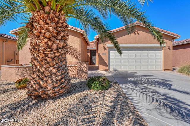 view of front of house featuring stucco siding, a garage, driveway, and a tiled roof