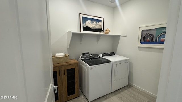 clothes washing area with washing machine and dryer