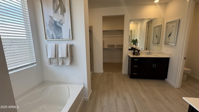 bathroom with vanity, hardwood / wood-style floors, toilet, and a bathing tub