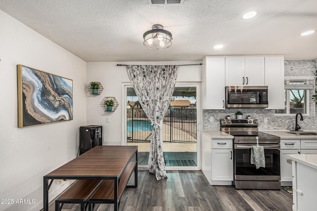 325 E Harmony Ave, Mesa, AZ 85210 - kitchen featuring appliances with stainless steel finishes, light countertops, dark wood-style flooring, white cabinets, and tasteful backsplash