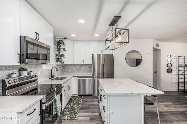 325 E Harmony Ave, Mesa, AZ 85210 - kitchen featuring appliances with stainless steel finishes, a kitchen island, dark wood-type flooring, a kitchen bar, and recessed lighting