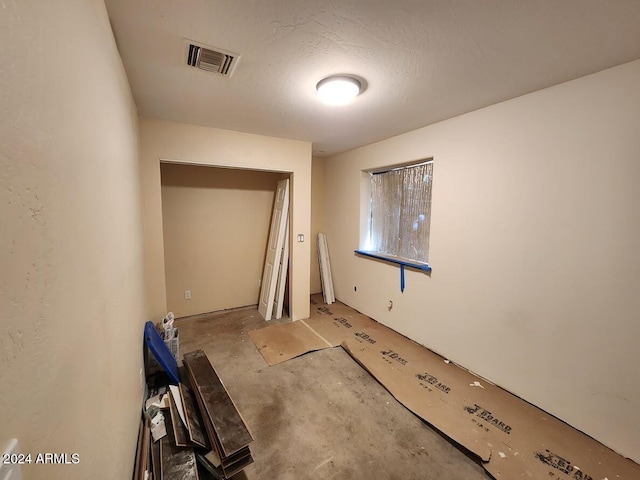 unfurnished room featuring a textured ceiling