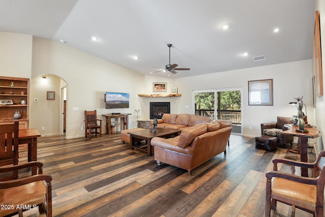 1604 W Beech Pkwy, Payson, AZ 85541 - living room featuring a ceiling fan, arched walkways, a warm lit fireplace, dark wood-style floors, and vaulted ceiling