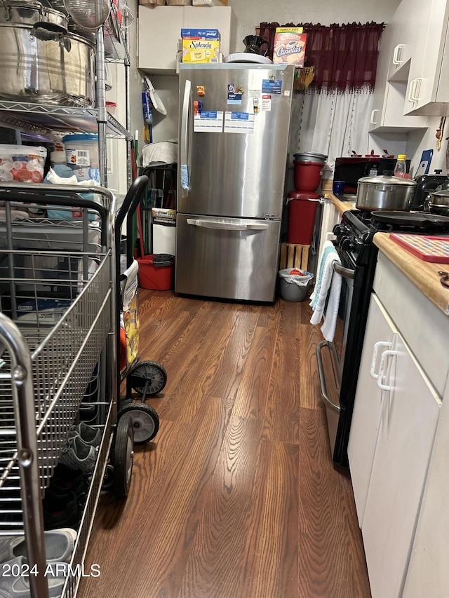 kitchen featuring appliances with stainless steel finishes, white cabinetry, and dark hardwood / wood-style floors