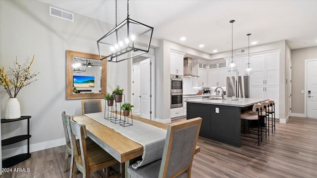 dining space featuring sink, dark wood-type flooring, and a notable chandelier