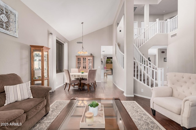 living room featuring visible vents, stairs, and wood finished floors