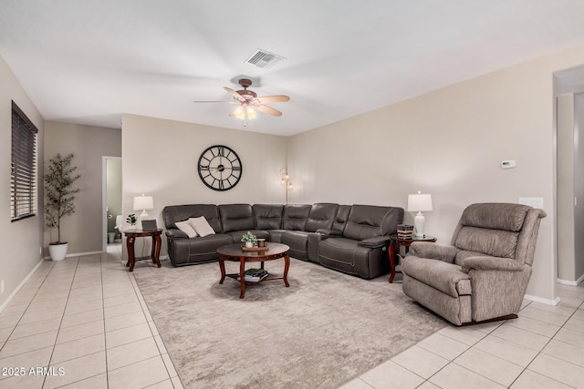 living room with light tile patterned floors, visible vents, baseboards, and a ceiling fan