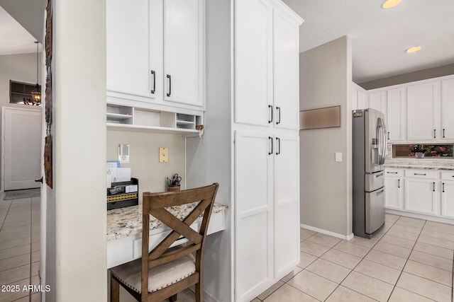 kitchen featuring light tile patterned floors, white cabinets, stainless steel refrigerator with ice dispenser, and light stone countertops