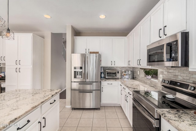 kitchen featuring stainless steel appliances, tasteful backsplash, and white cabinetry