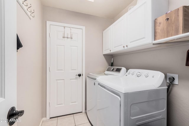 laundry area with light tile patterned floors, cabinet space, and separate washer and dryer