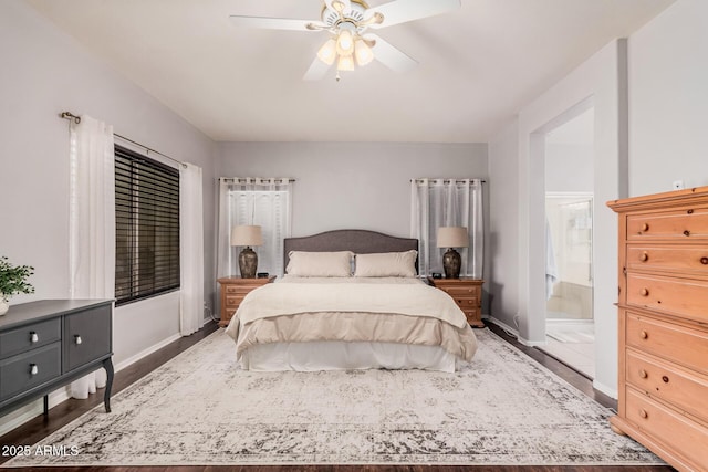 bedroom with connected bathroom, ceiling fan, baseboards, and wood finished floors