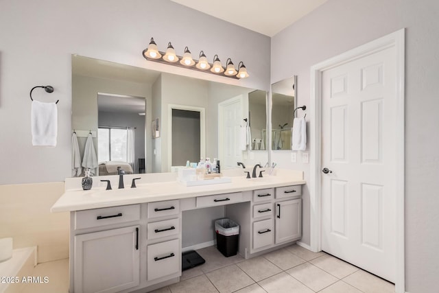 full bath with a sink, double vanity, and tile patterned flooring