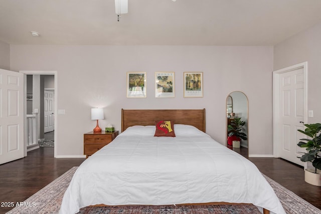 bedroom with ceiling fan, baseboards, and dark wood finished floors