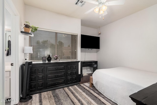 bedroom with ceiling fan, visible vents, and wood finished floors