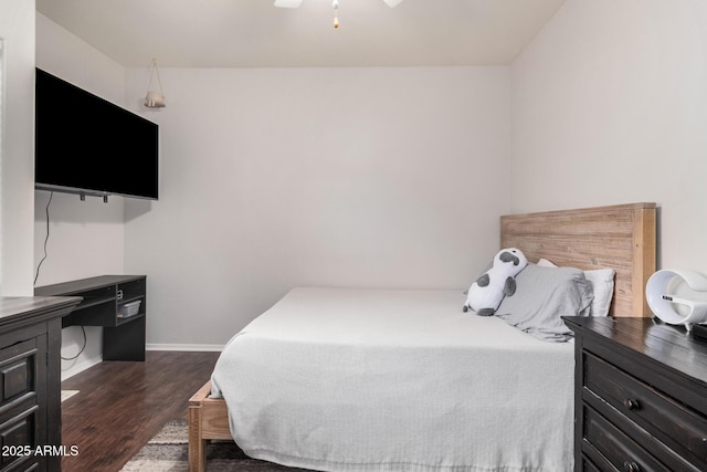 bedroom featuring baseboards and dark wood-style flooring