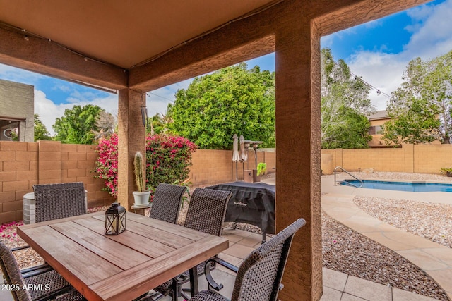 view of patio featuring outdoor dining space, a fenced backyard, and a fenced in pool