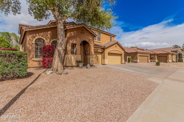 mediterranean / spanish-style house with stucco siding, a garage, driveway, and a tile roof