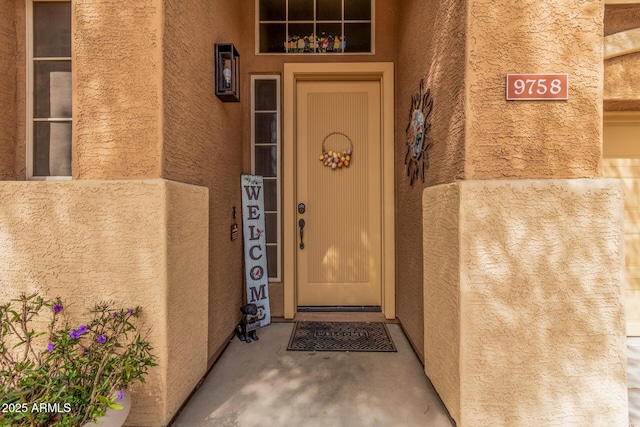 entrance to property featuring stucco siding