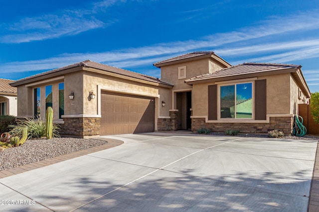 prairie-style home with a garage, stone siding, and stucco siding