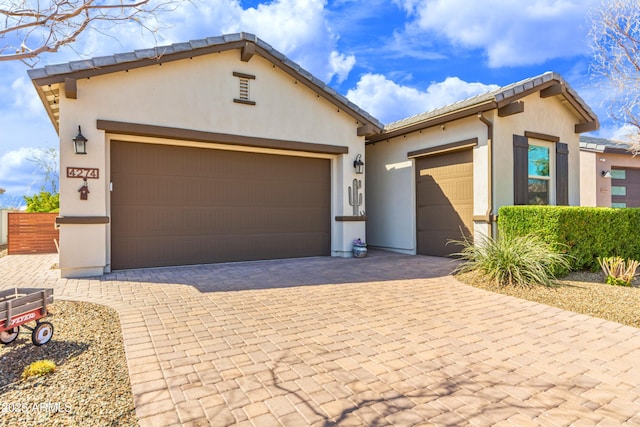 view of front of property with a garage, decorative driveway, and stucco siding