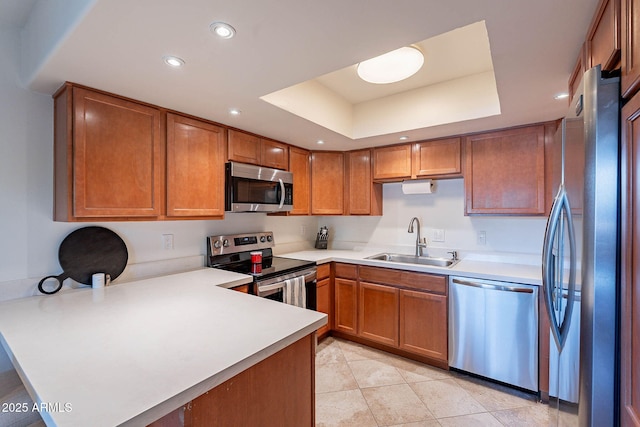 8414 N Central Ave Unit C, Phoenix, AZ 85020 - kitchen with appliances with stainless steel finishes, a sink, a peninsula, a tray ceiling, and brown cabinetry
