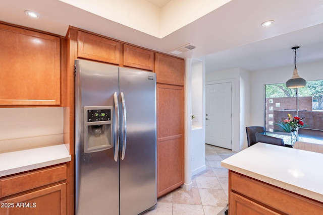 8414 N Central Ave Unit C, Phoenix, AZ 85020 - kitchen with stainless steel fridge with ice dispenser, brown cabinetry, light countertops, pendant lighting, and light tile patterned flooring